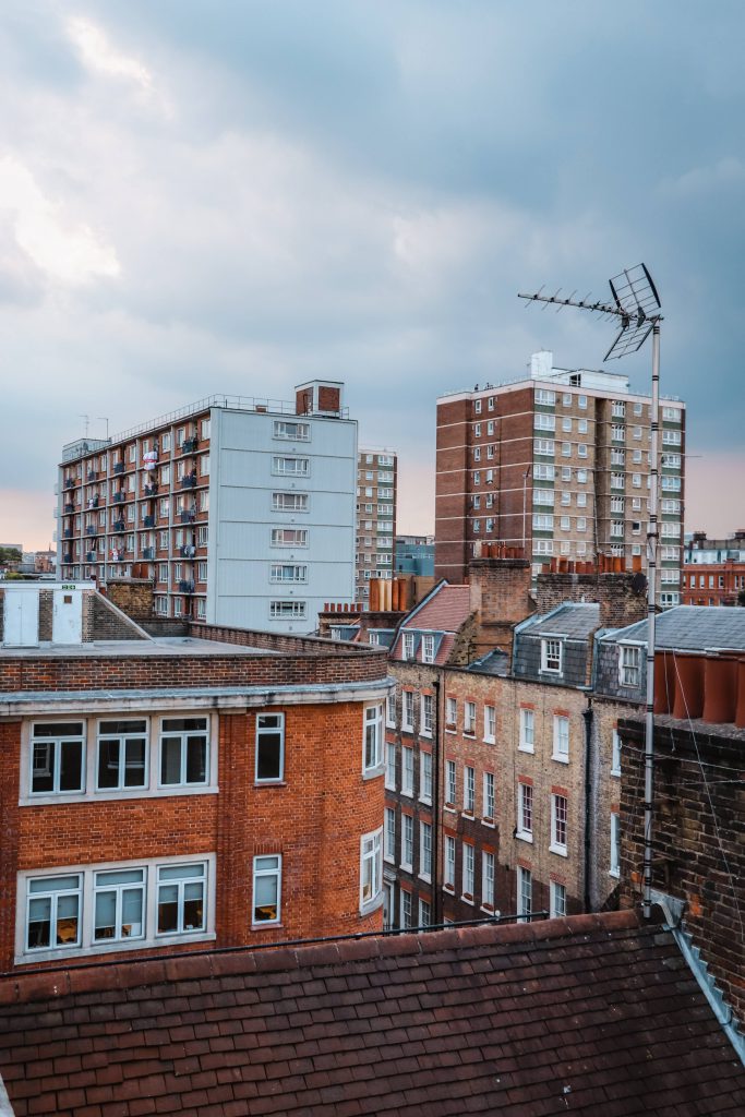 A view of 2 tall blocks of flats and other properties