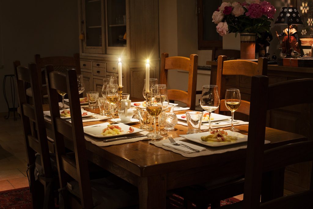 A table set for a family dinner with candles and wine. To demonstrate the potential risks of unattended candles.
