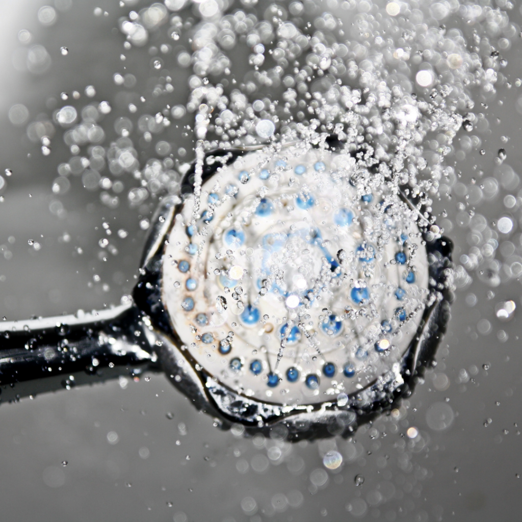 Shower head with water coming out - showing a way in which Legionnaires disease can be contracted 